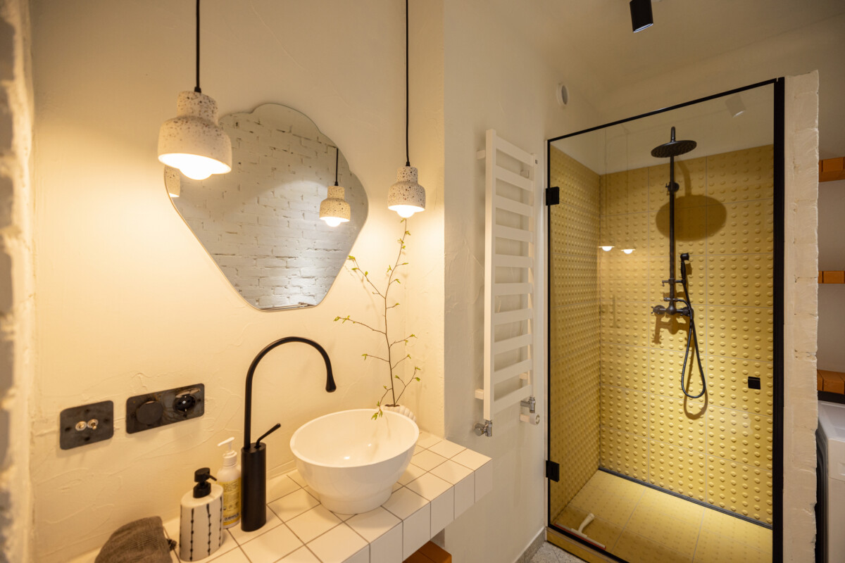 Stylish bathroom interior in white tones with shower and sink on tiled table top